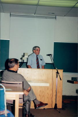 Dr. Harvey Plett, BMD chairman (standing); Rev. Ron Penner (seated)