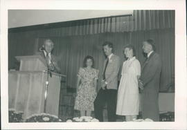 Moderator Harvey Plett welcoming Grande Prairie Church. L-R: Trudy & Peter Dueck, Audrey &amp...