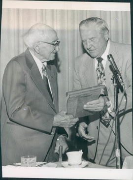 Mr. C. F. Friesen receiving plaque from Mayor A.D.Penner