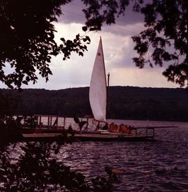 Campers at the dock with a sail boat at Fraser Lake Camp in Bancroft, Ontario