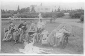 Children, youth and one adult man in wheel chairs on the grounds of the Mennonite Youth Farm