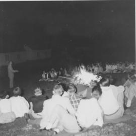 Young people gathered around a bonfire at Chesley Lake Camp
