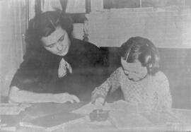 Mary Ellen Shoup helps a girl with homework