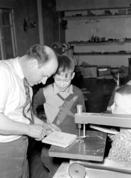Stan Good doing woodworking with boys at Goodwill Hall in Kitchener, Ontario