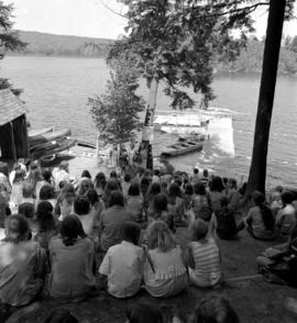 Campers sitting on water's edge at Fraser Lake Camp