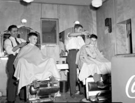 Jacob Kutz and son cutting boy's hair in their barber shop