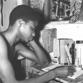 African high school student works at a small desk