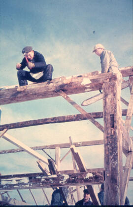 Barn raising crew securing rafters with spikes