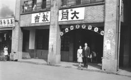 Pastor and Mrs. Chen Chin-chang stand in front of the meeting place of the Ta Tung Mennonite Chur...