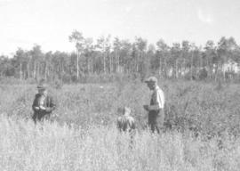 Two men & a boy are beside the wheat field