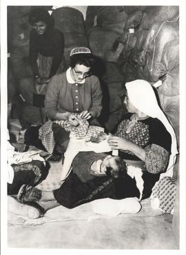 Lois Ruegg working on a layette with a refugee mother at Ein es Sultan