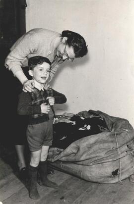 German child receiving clothes from MCC