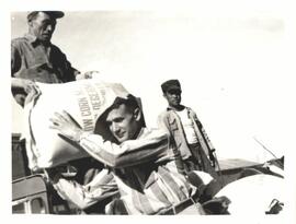 Harry Harms, director of material aid in Korea, helping to unload cornmeal for distribution in Daegu