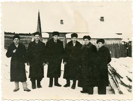 Six men in front of a Soviet barricks.