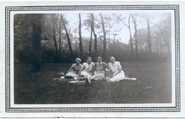 Four Maedchenheim women sitting in on the ground in a park.