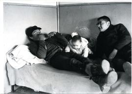 Billy Moore with man and baby on bed