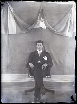 Interior portrait of a man sitting on a chair.