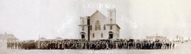 Members of the Corn Mennonite Brethren Church standing outside church building, 1925