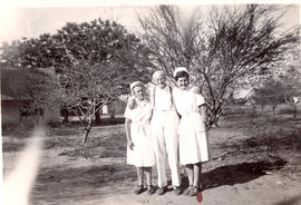 Two nurses helping C.N. Hiebert walk after an operation in Paraguay